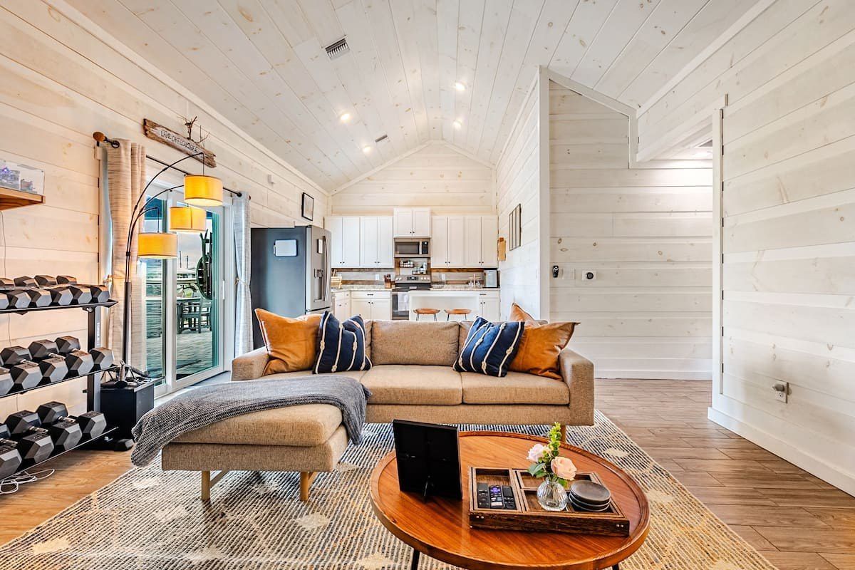 Living room with a tan sectional and wood-plank walls